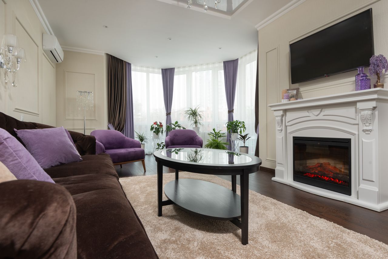 Cozy modern living room featuring a fireplace, plush furniture, and elegant decor.
